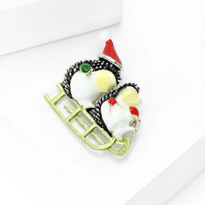Close-up of cute hedgehog Christmas brooch featuring red hat and green sleigh details