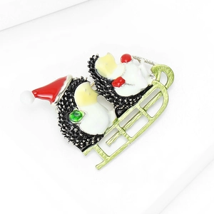 Detail of hedgehog brooch on a green sleigh with red Santa hat and green rhinestone
