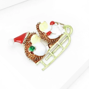 Detail of Christmas hedgehog brooch featuring red enamel hats on a golden sleigh