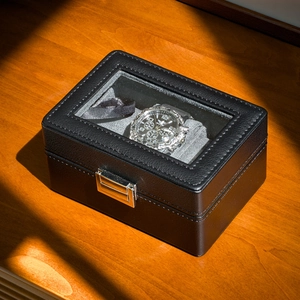 Detail of premium black PU leather watch box with metal lock and clear glass window