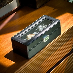 Detail of premium black PU leather watch box with white stitching and silver metal buckle