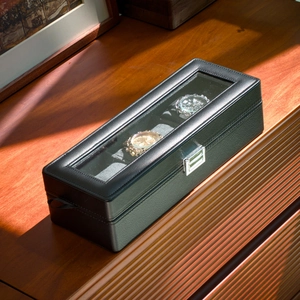 Macro view of black PU leather watch box with glass window and silver metal buckle