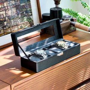 Detail view of a 6-slot black PU leather watch box with clear glass lid and gray velvet lining