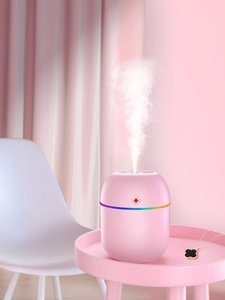 Nahaufnahme des rosa Kapsel-Luftbefeuchters mit Regenbogen-LED-Licht und Sprühnebel