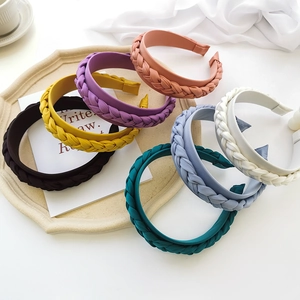 Detail of braided twist headbands in various colors on an elegant beige stone tray