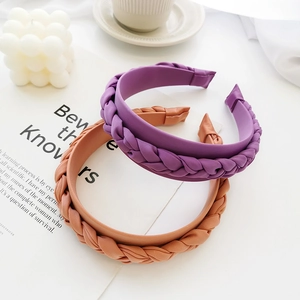 Close-up of purple and brown braided headbands with elegant lifestyle props