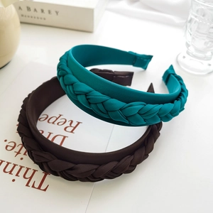 Detail view of woven braided headbands in cyan and coffee matte fabric textures