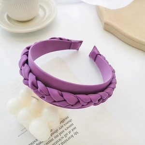 Detail of purple braided fabric headband placed on a modern artistic background