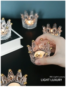 Macro shot of crown-shaped glass jewelry holder with gold tips for tea light candles