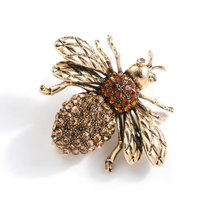 Exquisite gold-tone bee brooch with brown and orange crystals on a plain background