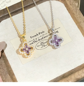 Detailed shot of gold and silver four-leaf clover necklaces with purple stones and diamonds