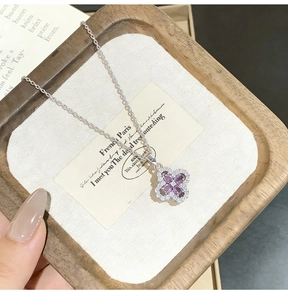 Close-up of four-leaf clover pendant with purple stones and micro-pave crystals