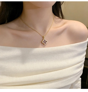Detail of clover necklace with purple stones and diamonds on model neck