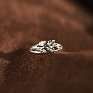 Detailed close-up of a silver leaf ring with pavé crystals and marquise stones