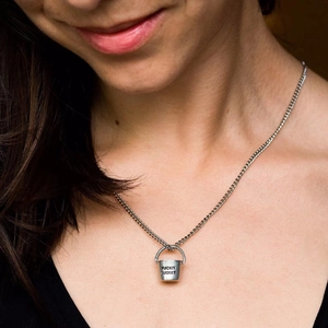 Silver bucket necklace with Fuckit Bucket engraving worn by model on black top