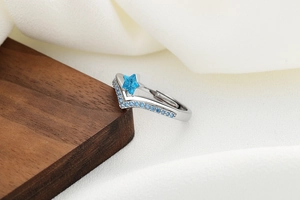Detail of adjustable silver star ring with a blue gemstone and pavé blue crystals