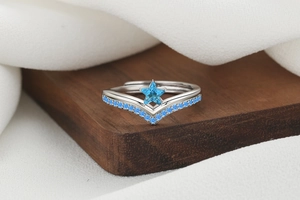 Macro shot of V-shaped silver ring featuring a blue star gemstone and pave small diamonds
