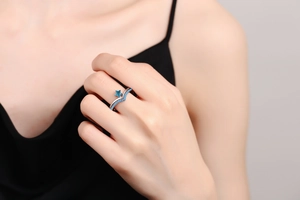 Macro detail of V-shaped silver ring with blue star gemstone and sparkling pavé accents