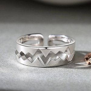 Macro shot of S925 sterling silver heartbeat rings showing the engraved hallmark