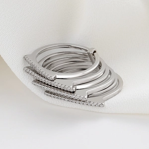 Modern multi-layer silver ring set with micro-paved cubic zirconia on white fabric