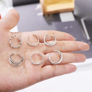 Detailed close-up of six silver-colored vintage cuff earrings with engraved patterns