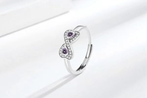 Dettaglio dell'anello infinito in argento con doppi cuori viola e zirconi incastonati