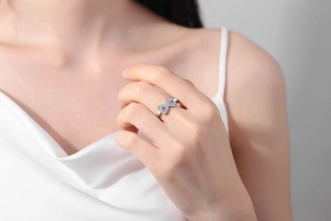 Primo piano dell'anello infinito con pietre a cuore viola e zirconi sulla mano