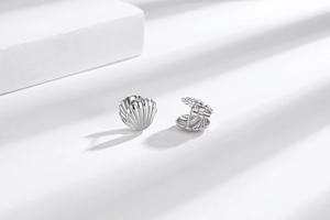 Detailed view of silver shell-shaped stud earrings with elegant vertical textured stripes