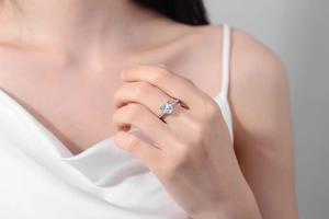 Close-up of elegant silver ring featuring a heart-cut pink cubic zirconia on hand