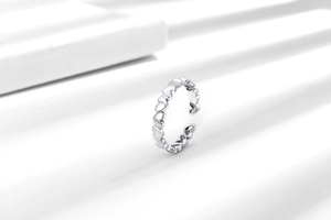 Detail shot of a minimalist silver heart-shaped open ring with multiple hollow heart patterns