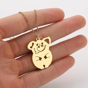 Detailopname van een schattige gouden varkenshanger aan een fijne metalen ketting