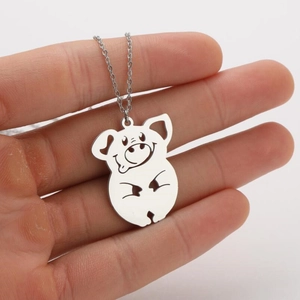 Detailopname van een schattige holle varkenshanger met ketting vastgehouden in de hand