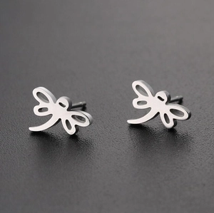 Close-up of minimalist silver dragonfly stud earrings with elegant hollowed-out design