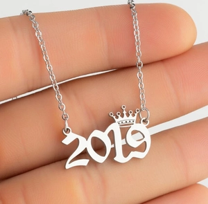 Macro view of 2019 number pendant necklace with a crown detail on silver-tone chain