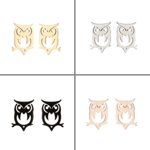 Vue macro des boucles d'oreilles hibou en or, argent, noir et or rose ajourées