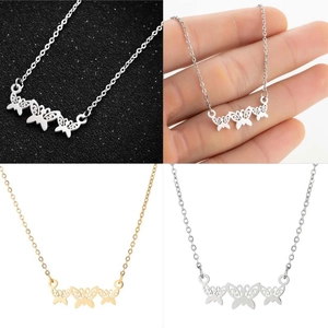Detail view of triple butterfly pendant necklace in polished silver and gold finishes