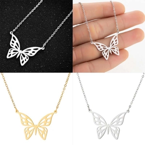 Detailed macro view of hollow butterfly pendants in silver and gold stainless steel
