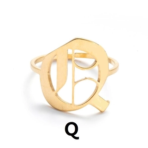 Nahaufnahme des goldenen Buchstabens Q auf einem Vintage-Ring aus Edelstahl