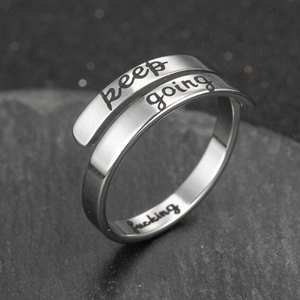 Minimalist stainless steel wrap ring engraved with keep going on textured stone