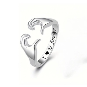 Detail of silver hugging hands ring with engraved I love you forever lettering