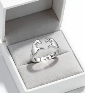 Macro detail of silver heart gesture ring with I Love You engraving in a gift box