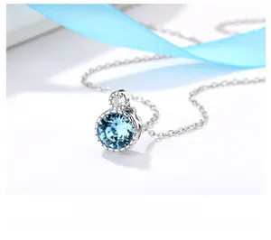 Macro shot of Heart of Ocean necklace with blue crystal pendant on a ribbon background