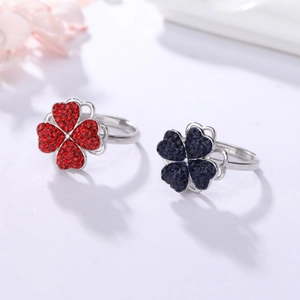 Set de bagues trèfle à quatre feuilles rotatif avec cristaux rouges et bleus sur fond blanc