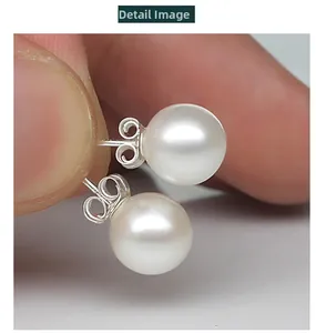 Detailed view of elegant white round pearl earrings with 925 sterling silver backings