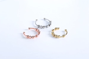 Detailed view of three adjustable fidget rings in rose gold, silver, and gold finishes