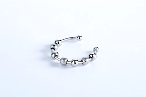 Macro detail of silver rotating beads with polished and frosted textures on an open ring