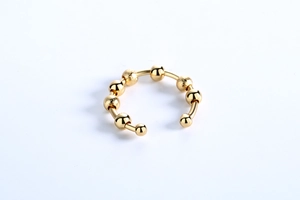 Detail view of adjustable gold ring with rotating polished and frosted sensory beads