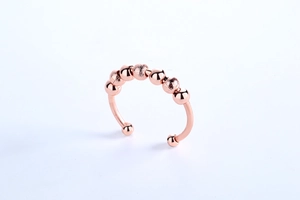 Detail of rose gold spinning anxiety ring showing alternating polished and frosted beads