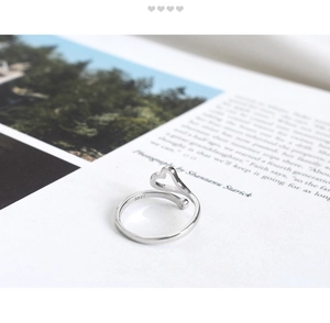 Detail of S925 sterling silver heart open ring with hallmark stamp on magazine background