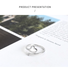 Detail of silver heart open ring featuring a hollow pattern and a tiny sparkling zircon